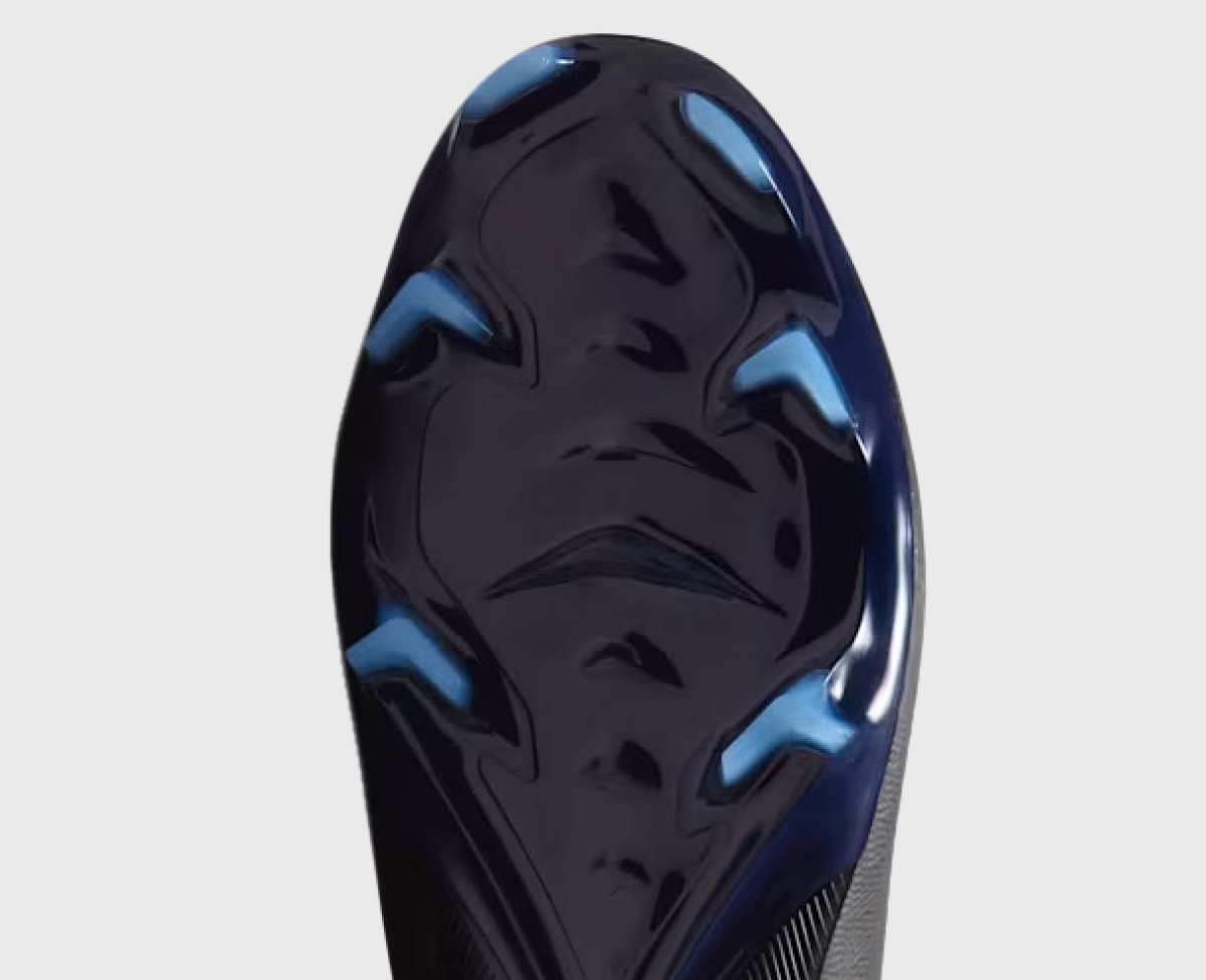 Firm Ground outsole viewed from below — a mix of bladed and conical studs optimized for natural grass